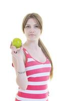 heureuse jeune femme mange une pomme verte isolée sur blanc photo