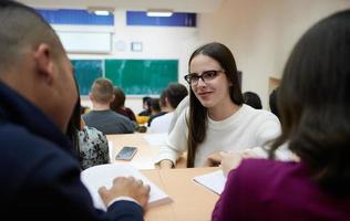 fille assise dans un amphithéâtre et parlant à ses collègues photo