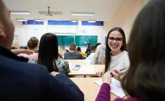 fille assise dans un amphithéâtre et parlant à ses collègues photo