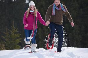 couple s'amusant et marchant en raquettes photo