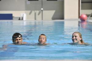 une jeune famille heureuse s'amuse à la piscine photo