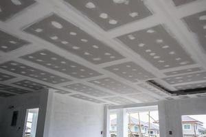 installation de plaques de plâtre au plafond sur un chantier de construction photo