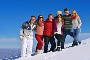 les amis s'amusent en hiver sur la neige fraîche photo