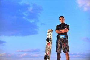 portrait d'un jeune homme kitsurf à la plage au coucher du soleil photo