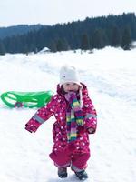 petite fille s'amuse sur la neige fraîche photo