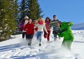 les amis s'amusent en hiver sur la neige fraîche photo