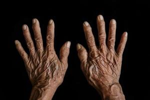 les mains de la vieille femme sur fond noir photo