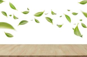 feuilles vertes tourbillonnantes volantes dans l'air avec table en bois, produits sains par concept d'ingrédients naturels biologiques, espace vide en studio tourné isolé sur fond blanc longue bannière photo