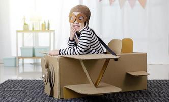 petite fille asiatique jouant avec de l'artisanat d'avion jouet en carton isolé dans une longue bannière à la maison avec un espace de copie pour votre texte, créatif avec la famille et rêvant de concept de vol photo