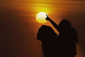 silhouette mère et fille au coucher du soleil photo