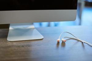 écouteurs et écran d'ordinateur sur le lieu de travail. travailler avec le son ou écouter de la musique au travail. écouter les conversations téléphoniques professionnelles photo