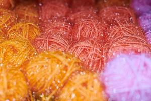 boules de fil de couleur orange et rouge dans l'atelier de tricot, macro photo