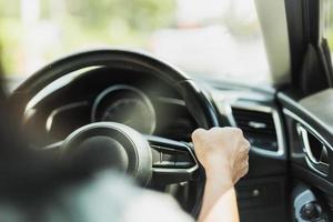 gros plan d'une femme au volant main tenant le volant en arrière-plan flou. photo