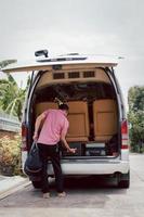 conducteur de voyage sur la route chargeant des bagages sur une camionnette de voyage. photo