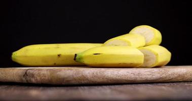 couper une banane jaune mûre en plusieurs morceaux avec un couperet photo