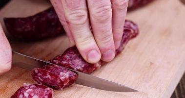 couper la saucisse finie en morceaux sur une planche à découper photo