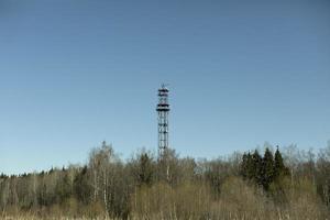 tour de communication au-dessus de la forêt. tour de télévision à l'extérieur de la ville. antenne d'alimentation de signal. photo