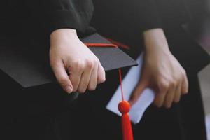 l'étudiant tient le chapeau à la main pendant le début du succès des diplômés de l'université, félicitations à l'éducation conceptuelle. cérémonie de remise des diplômes. mise au point douce photo