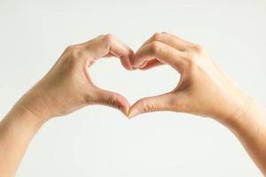 les mains affichent le signe de l'amour en épissant le bout des doigts ensemble pour former un cadre cardiaque. photo