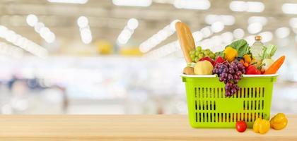 panier rempli de fruits et légumes sur table en bois avec supermarché épicerie arrière-plan flou défocalisé photo