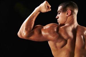 Bodybuilder mâle flexion des biceps, vue arrière avec copie espace photo