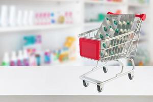 capsule de pilules de médecine dans le panier sur le comptoir du magasin de pharmacie avec des étagères de pharmacie floues arrière-plan défocalisé photo