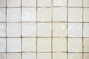 Le vieux mur blanc de carreaux sales dans la salle de bain n'a pas encore été nettoyé. photo