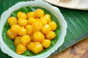 kanom thongyip et thongyhod, boules de fudge au jaune d'œuf cuites au sirop sur une feuille de bananier vue de dessus dans le petit plat prêt à servir pour le dessert. photo