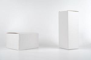 deux boîtes de papier blanches - hautes et grasses reposent sur le fond blanc en studio tourné avec un chemin de détourage. photo