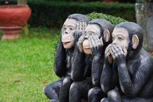 statue de trois singes noirs, ferme les yeux, la bouche, l'oreille. photo