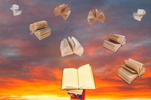livre au-dessus de la pile de livres et ciel coucher de soleil photo