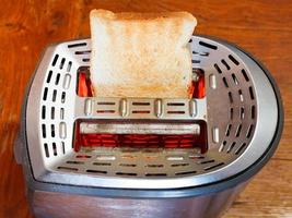 une tranche de pain grillée sur un grille-pain en métal chaud photo