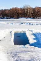 trou de glace dans un étang gelé photo