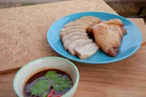 rôti de porc et sauce épicée thaïlandaise sur table en bois. cuisine de rue en thaïlande.