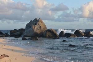 vagues se brisant sur des rochers arrondis à aruba photo