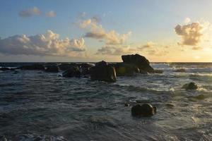 Lever de soleil sur les formations rocheuses le long de la côte d'Aruba photo