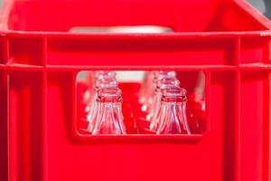 caisse en plastique rouge avec des bouteilles en verre vides photo