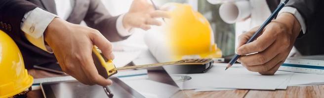 Deux collègues discutant des données de travail et tablette, ordinateur portable avec sur le projet architectural sur le chantier de construction au bureau au bureau photo