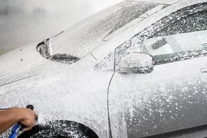 lavage de voiture nettoyage avec de la mousse et de l'eau haute pression photo