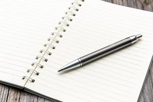 cahier avec le stylo plume sur le bureau en bois photo