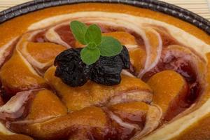 Gâteau aux prunes dans un bol sur fond de bois photo