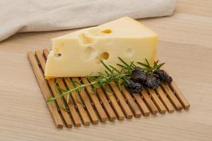 Fromage maasdam sur planche de bois et fond de bois photo