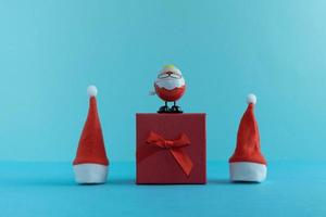 père noël, cadeaux et chapeaux de père noël sur fond bleu. notion de nouvel an. joyeux Noël. photo