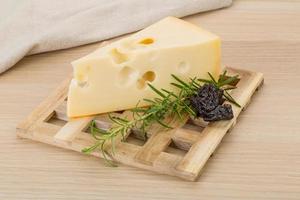 Fromage maasdam sur planche de bois et fond de bois photo