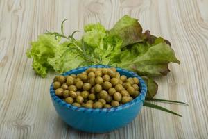 pois marinés dans un bol sur fond de bois photo