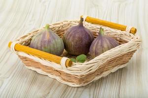 figues dans un panier sur fond de bois photo