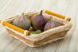 figues dans un panier sur fond de bois photo