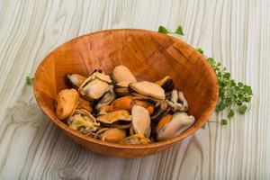 moules dans un bol sur fond de bois photo