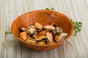 moules dans un bol sur fond de bois photo