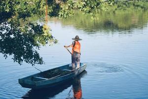 homme dégageant de l'herbe sur l'eau photo